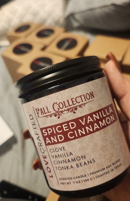 Hand holding a Spiced Vanilla and Cinnamon candle showing its Fall Collection label
